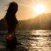 woman in black bikini top standing on water during daytime