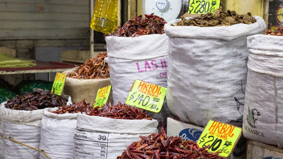Bags of dried chilies for sale at a market in Mexico City, showcasing a colorful variety.